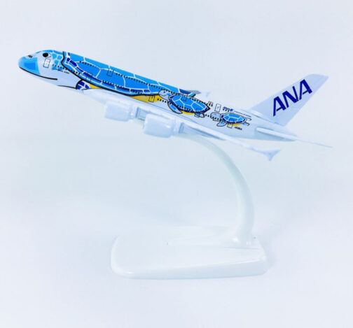 Model airplane with blue turtle design on stand.