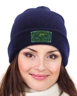 Woman wearing navy beanie with label design.