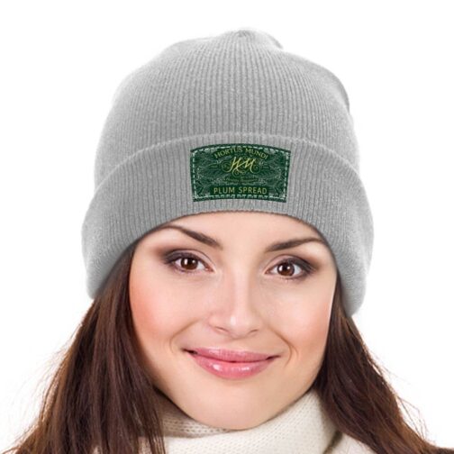 Woman wearing gray beanie with Hortus Mundi label.