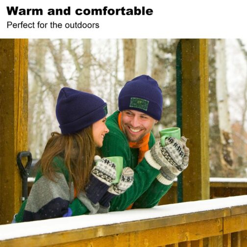 Couple in winter clothes with mugs, smiling.